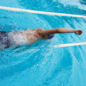 Person swimming backstroke in pool