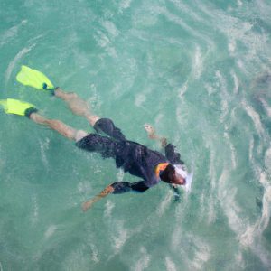 Person snorkeling in crystal-clear water