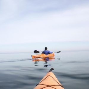 Person kayaking on calm water