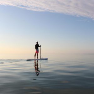 Person paddleboarding on calm water